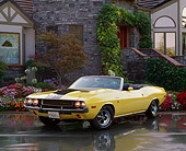 AUT 23 RK0623 02
1970 Dodge Challenger 440 Convertible Yellow With Black Stripes 3/4 Front View On Wet Pavement By House