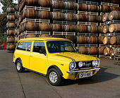 AUT 23 RK0682 05
1970 Mini Estate Clubman Yellow 3/4 Front View On Pavement By Barrels