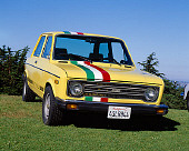 AUT 23 RK0772 04
1978 Fiat 128 Rally Car Yellow With Stripes 3/4 Front View On Grass Hill