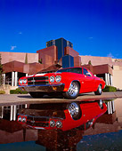 AUT 23 RK0809 03
1970 Chevrolet El Camino SS 454 Red With White Stripes 3/4 Low Front View On Pavement By Puddle And Museum