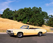 AUT 23 RK0857 04
1970 Buick GS455 Convertible Yellow 3/4 Side View On Pavement By Dry Grass Hill And Trees