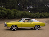 AUT 23 RK1129 01
1972 Chevrolet Monte Carlo Candy Lime Gold 3/4 Side View On Dirt Trees Background