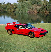 AUT 24 RK0031 07
1986 De Tomaso Pantera GT5-S Red 3/4 Front View On Grass By Lake