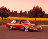 AUT 24 RK0089 06
1984 Oldsmobile Cutlass Supreme Lowrider Burgundy 3/4 Side View On Pavement By Yellow Flowers And Trees Filtered
