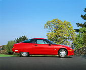 AUT 25 RK1173 03
1999 General Motors EV1 Electric Car Red Low Profile View On Pavement Trees Blue Sky