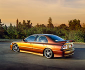 AUT 25 RK1260 06
1996 Honda Accord DX Custom Bronze 3/4 Rear View On Pavement Trees Background