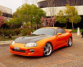AUT 25 RK1265 02
1995 Toyota Supra Custom Orange And Black 3/4 Front View By Building And Trees