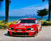 AUT 25 RK1375 02
1999 Nissan Skyline Nismo Race Car Red 3/4 Front View By Water City Background