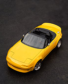 AUT 25 RK0092 01
1997 Mazda Miata V8 Yellow Convertible Overhead 3/4 Front View On Pavement