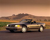 AUT 25 RK0192 11
1994 Mercedes-Benz 600SL Roadster Black 3/4 Side On Road Headlights On By Dry Grass Mountains In Backgrnd
