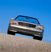 AUT 25 RK0228 04
1990 Mercedes-Benz 500SL Convertible Silver Slanted Head On Shot On Pavement Hill Blue Sky