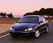 AUT 25 RK0302 10
1996 Ford Taurus Blue 3/4 Front View On Pavement Trees Background At Dusk