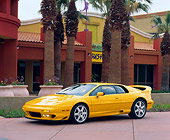AUT 25 RK0433 07
1997 Lotus Esprit V8 Yellow Side 3/4 View By Palm Trees And Buildings