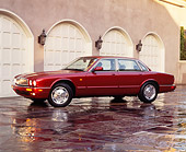 AUT 25 RK0455 03
1995 XJ6 Jaguar Red 3/4 Side View On Driveway In Front Of Garage Headlights On