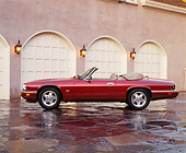 AUT 25 RK0459 08
1995 Red XJS Jaguar Convertible Side View On Driveway In Front Of Garage Headlights On