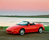 AUT 25 RK0512 02
1991 Lotus Elan Convertible Red 3/4 Side View On Dirt By Water Filtered