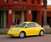 AUT 25 RK0682 09
1998 Volkswagen Beetle, Yellow slight 3/4 on pavement, lights on in front of red building with palm trees and flower planters