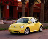 AUT 25 RK0683 03
1998 Volkswagen New Beetle Yellow 3/4 Front View On Pavement By Palm Trees And Building