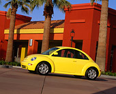 AUT 25 RK0687 01
1998 Volkswagen Beetle Yellow Slanted Profile On Pavement By Palm Trees And Buildings