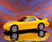 AUT 25 RK0895 02
1993 Mazda RX7 R1 Yellow Side 3/4 View On Mylar Floor Sunset Sky