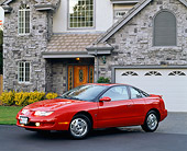 AUT 25 RK1032 06
1999 Saturn 3 Door Coupe Red 3/4 Side View On Driveway By House