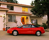 AUT 25 RK1034 03
1999 Saturn SC 3 Door Coupe Red Profile View On Driveway By House At Dusk