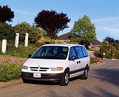 AUT 25 RK1059 03
1996 Dodge Caravan White Front 3/4 View On Pavement By Trees And Bushes