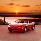 AUT 25 RK1115 01
1990 Mazda Miata Convertible Red 3/4 Front View On Pavement By Water At Sunset