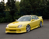 AUT 25 RK1209 04
1999 Honda Prelude SH Yellow Front 3/4 View On Pavement By Trees