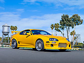 AUT 25 RK1431 01
1998 Toyota Supra Custom Yellow 3/4 Front View On Pavement By Trees Blue Sky