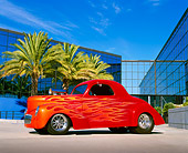 AUT 26 RK0329 06
1941 Willys Prostreet Coupe Red With Flames 3/4 Side View On Pavement By Glass Building