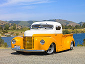 AUT 26 RK2777 01
1947 International Pickup Truck Hot Rod Orange And White 3/4 Front View On Gravel By Lake And Hills