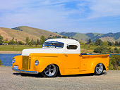 AUT 26 RK2778 01
1947 International Pickup Truck Hot Rod Orange And White 3/4 Front View On Gravel By Lake And Hills