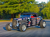 AUT 26 RK2919 01
1932 Ford Roadster Hot Rod Black With Decals 3/4 Front View On Pavement By Trees
