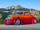 AUT 26 RK3062 01
1937 Chevrolet Coupe Candy Red And Tangerine 3/4 Front View On Pavement By Mountains