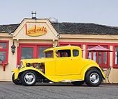 AUT 26 RK3105 01
1930 Ford Model A 5 Window Coupe Yellow Profile View On Pavement By Restaurant