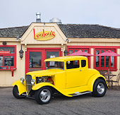 AUT 26 RK3106 01
1930 Ford Model A 5 Window Coupe Yellow 3/4 Front View On Pavement By Restaurant