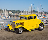 AUT 26 RK3107 01
1930 Ford Model A 5 Window Coupe Yellow 3/4 Front View On Pavement By Harbor