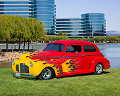 AUT 26 RK3333 01
1941 Chevrolet 2-Door Sedan Red With Flames 3/4 Front View On Grass By Lagoon And Glass Buildings
