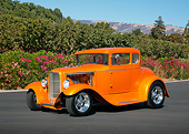 AUT 26 RK3352 01
1930 Ford Coupe Pearl Orange 3/4 Front View On Pavement By Pink Flowers And Shrubs