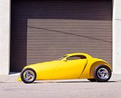 AUT 26 RK0061 05
Aluma Coupe Yellow Hot Rod Profile View By Garage Door