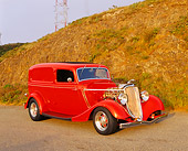 AUT 26 RK0179 03
1933 Ford Delivery Sedan Red 3/4 Front View On Pavement By Dry Grass Hill