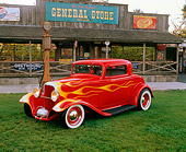 AUT 26 RK0191 02
1932 Ford 3-Window Coupe Red With Flames 3/4 Front View On Grass By Store
