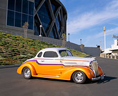 AUT 26 RK0202 05
1937 Chevrolet Master Coupe Orange And White 3/4 Front View On Pavement By Stadium