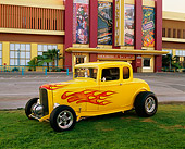 AUT 26 RK0266 05
1932 Ford Coupe Yellow With Flames 3/4 Side View On Grass By Building