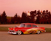 AUT 26 RK0298 07
1956 Custom Chevrolet Bel Air Orange With Graphics 3/4 Front View By Trees