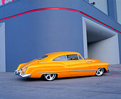 AUT 26 RK0358 02
1950 Buick Sedanette Tangerine 3/4 Rear View On Pavement By Building