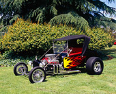 AUT 26 RK0558 03
1923 Ford Roadster Pickup Truck Hot Rod Black With Flames 3/4 Front View On Grass By Shrubs Trees