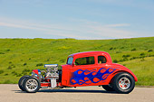 AUT 26 RK1249 01
1934 Chevrolet 5-Window Coupe Hot Rod Red With Blue Flames 3/4 Front View By Grass Hill Blue Sky