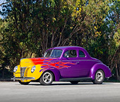 AUT 26 RK2751 01
1940 Ford Coupe Hot Rod Purple With Flames 3/4 Front View On Pavement By Trees